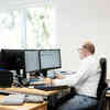 Ein ttp Mitarbeiter sitzt mit Headset am Schreibtisch