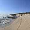 3 Surfer laufen am Strand.