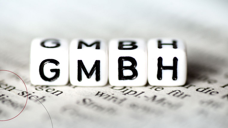 Vier Würfel mit den aufgedruckten Buchstaben "G-M-B-H".